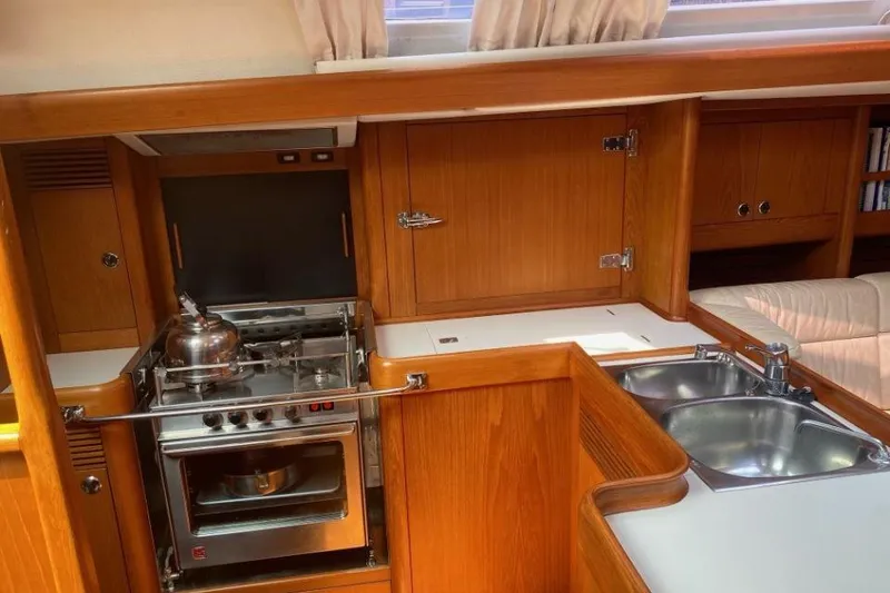 Slide: The Image of Interior of 1992 Nautor Swan 44 yacht kitchen with stove, sink, and wooden cabinetry. - 4