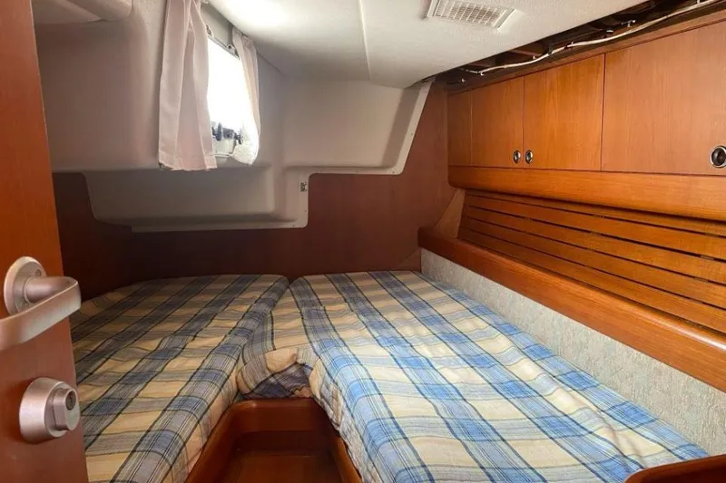 Slide: The Image of Cozy cabin interior of 1992 Nautor Swan 44 sailboat with twin beds and wooden cabinetry. - 6