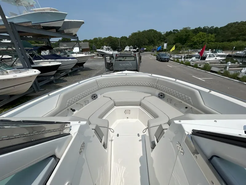 Slide: The Image of 2026 Pursuit DC 326 boat interior with seating, docked among other boats. - 17