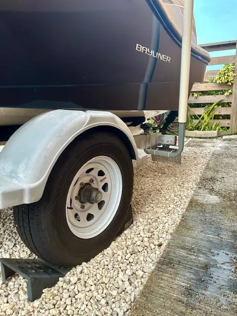 Slide: The Image of 2022 Bayliner DX2000 boat on trailer, parked on gravel surface. - 10