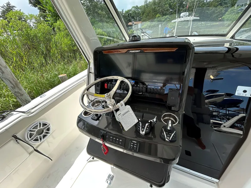 Slide: The Image of 2026 Pursuit S 328 boat helm with steering wheel and control panel. - 13