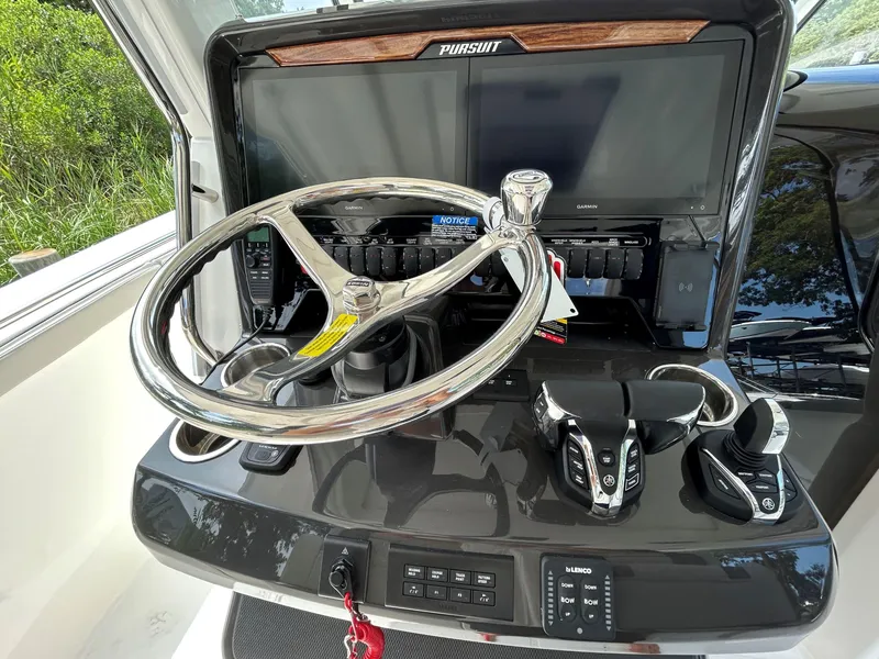 Slide: The Image of 2026 Pursuit S 328 boat helm with steering wheel and control panel. - 14