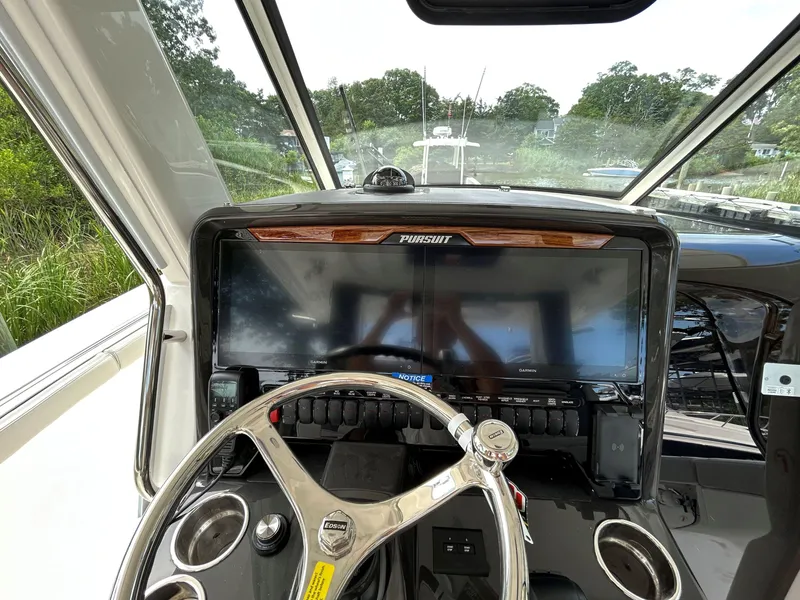 Slide: The Image of 2026 Pursuit S 328 boat dashboard with steering wheel and navigation display. - 15