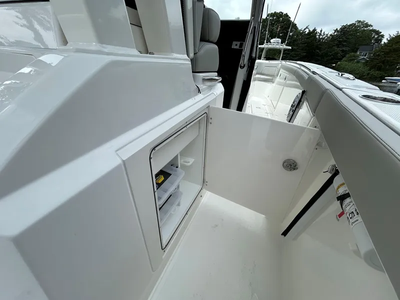 Slide: The Image of 2026 Pursuit S 328 boat interior with open storage compartment and seating area. - 21