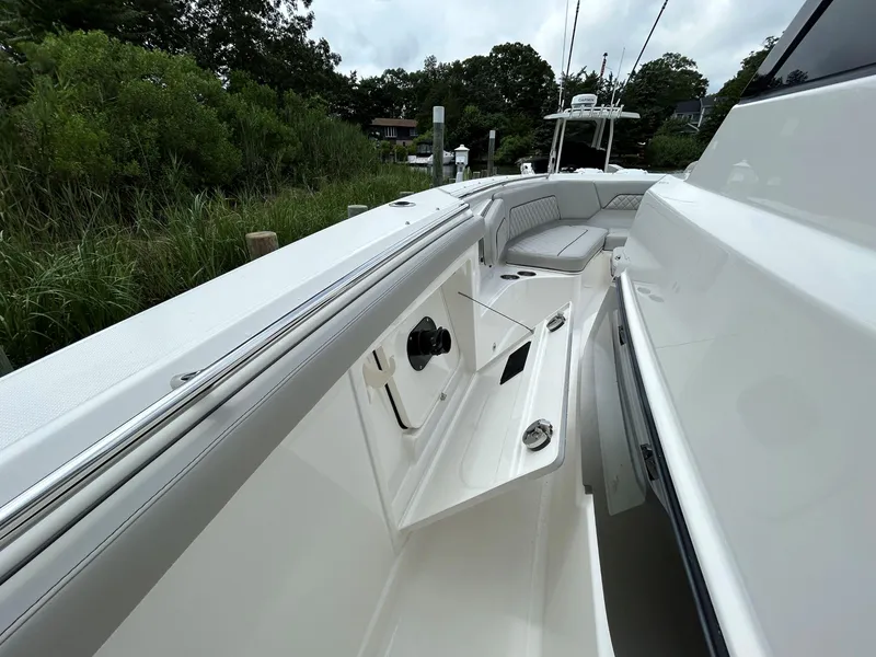 Slide: The Image of 2026 Pursuit S 328 boat interior with open storage compartment and seating area. - 22
