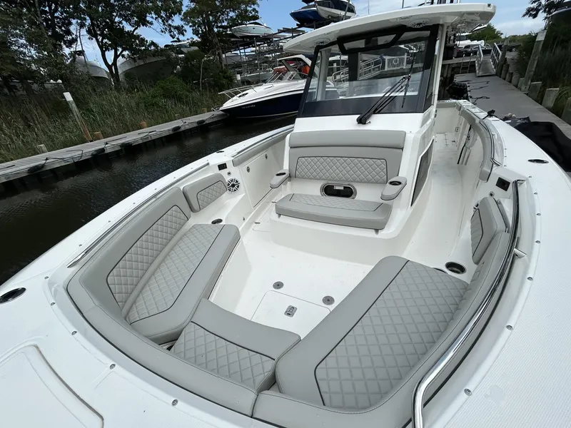 Slide: The Image of 2026 Pursuit S 328 boat with luxurious seating and sleek design at a marina. - 25