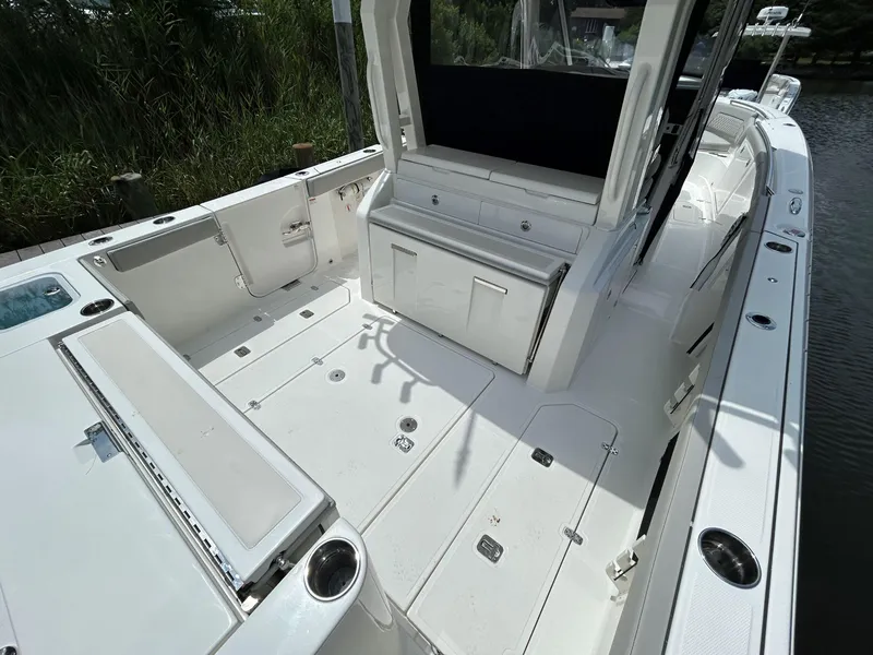 Slide: The Image of 2026 Pursuit S 328 boat deck with seating and storage, docked by water. - 5