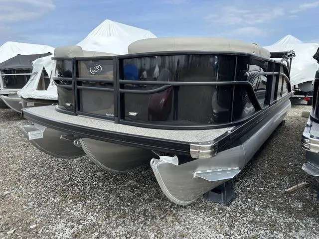 Slide: The Image of 2025 Barletta Boats C20UC pontoon boat on gravel lot, covered in white tarps. - 1
