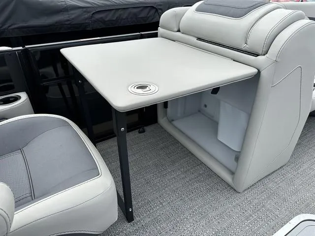 Slide: The Image of 2025 Barletta Boats C20UC interior with a sleek table and cushioned seating. - 14