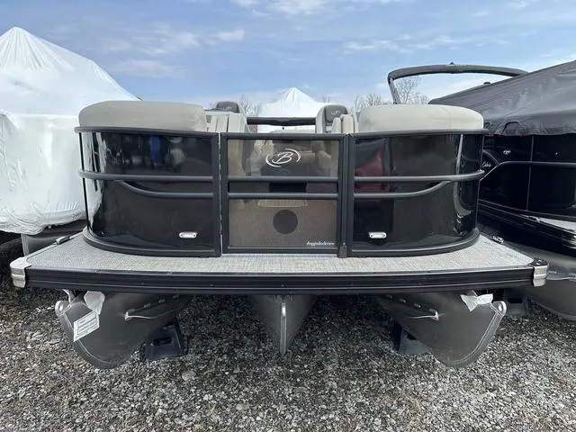 Slide: The Image of 2025 Barletta Boats C20UC pontoon, black exterior, parked on gravel, under a cloudy sky. - 2