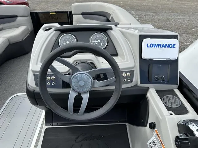 Slide: The Image of 2025 Barletta C20UC boat dashboard with steering wheel and Lowrance navigation system. - 25