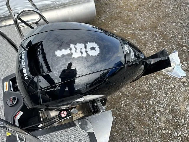 Slide: The Image of 2025 Barletta C20UC boat with Mercury 150 outboard engine, parked on gravel. - 40