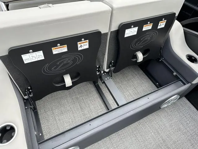 Slide: The Image of 2025 Barletta Boats C20UC seating area with storage compartments and safety labels. - 8