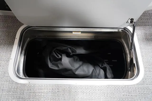 Slide: The Image of Open storage compartment in 2025 Barletta Corsa 23UC boat, featuring a black cover inside. - 33