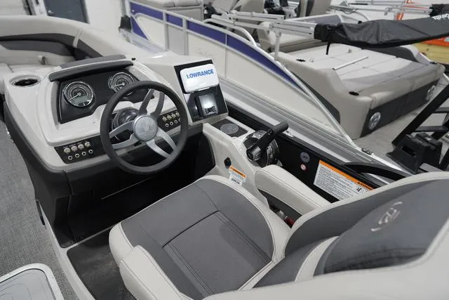 Slide: The Image of 2025 Barletta Boats C22QC cockpit with steering wheel, gauges, and Lowrance display. - 10
