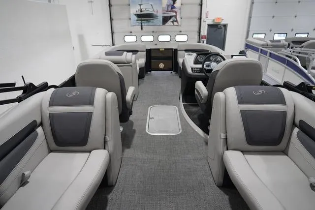Slide: The Image of 2025 Barletta Boats C22QC interior with luxurious seating and modern dashboard in a showroom. - 38