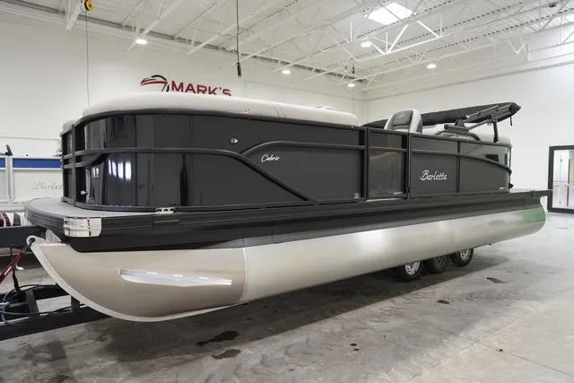 Slide: The Image of 2025 Barletta Boats C22QC pontoon in showroom, sleek black design, on trailer. - 4