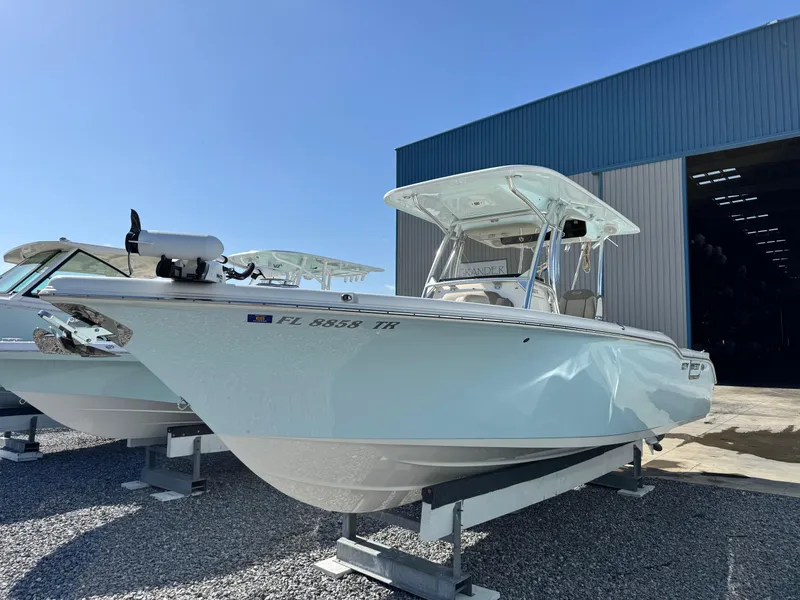 Slide: The Image of 2024 Key West 263 FS boat displayed outdoors near a warehouse. - 1