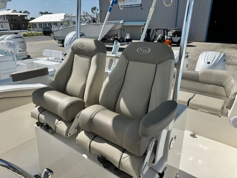 Slide: The Image of 2024 Key West 263 FS boat with luxurious beige captain seats in a marina setting. - 17