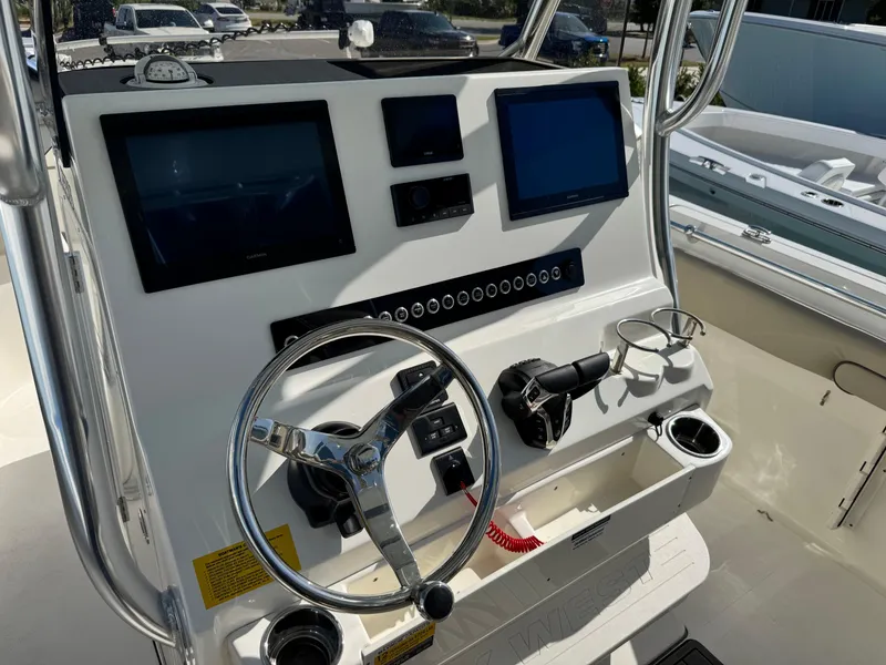 Slide: The Image of 2024 Key West 263 FS boat dashboard with dual screens and steering wheel. - 19