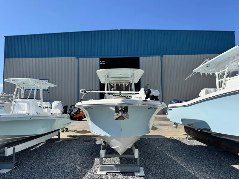 Slide: The Image of 2024 Key West 263 FS boat displayed outside a large blue warehouse. - 2