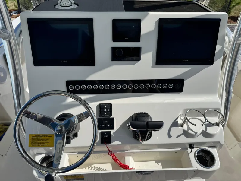 Slide: The Image of 2024 Key West 263 FS boat dashboard with dual screens, steering wheel, and control panel. - 20