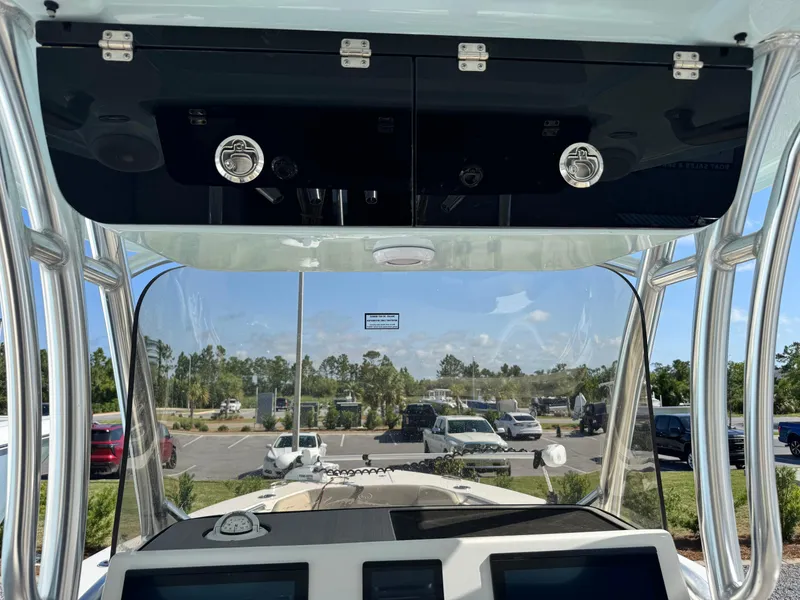 Slide: The Image of 2024 Key West 263 FS boat dashboard with overhead storage and clear windshield view. - 21