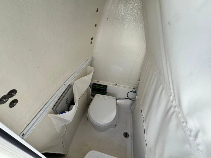 Slide: The Image of 2024 Key West 263 FS boat interior with compact marine toilet and storage pockets. - 24
