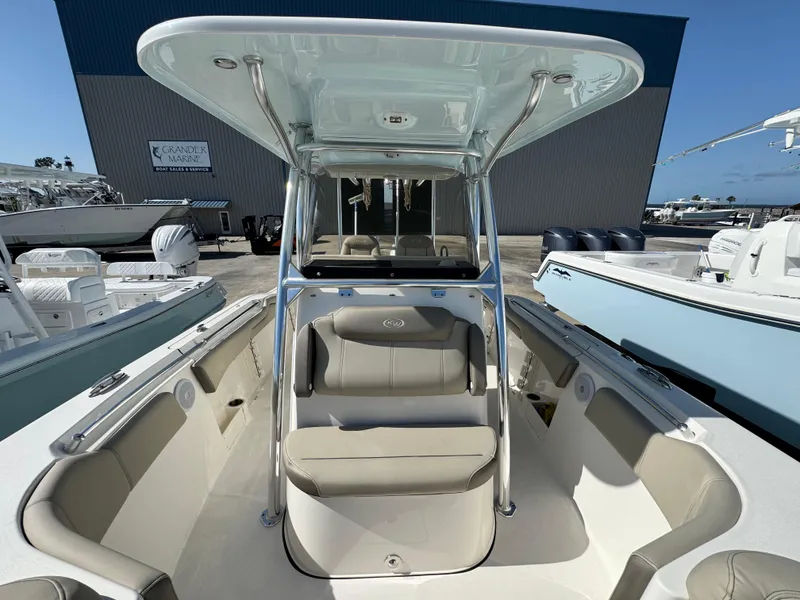 Slide: The Image of 2024 Key West 263 FS boat interior with seating and T-top in a marina setting. - 26