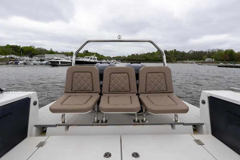 Slide: The Image of 2019 Axopar 37 Cabin boat with three cushioned seats, docked on a cloudy day. - 10