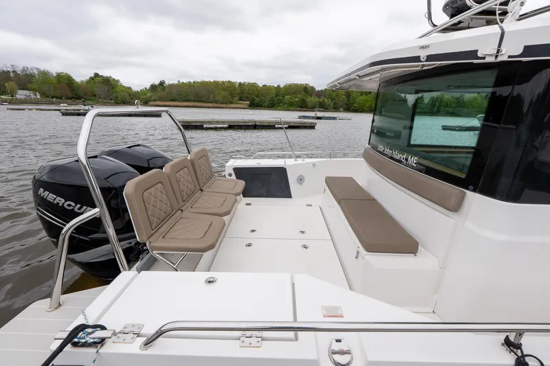 Slide: The Image of 2019 Axopar 37 Cabin boat with seating and Mercury engines on a calm lake. - 12