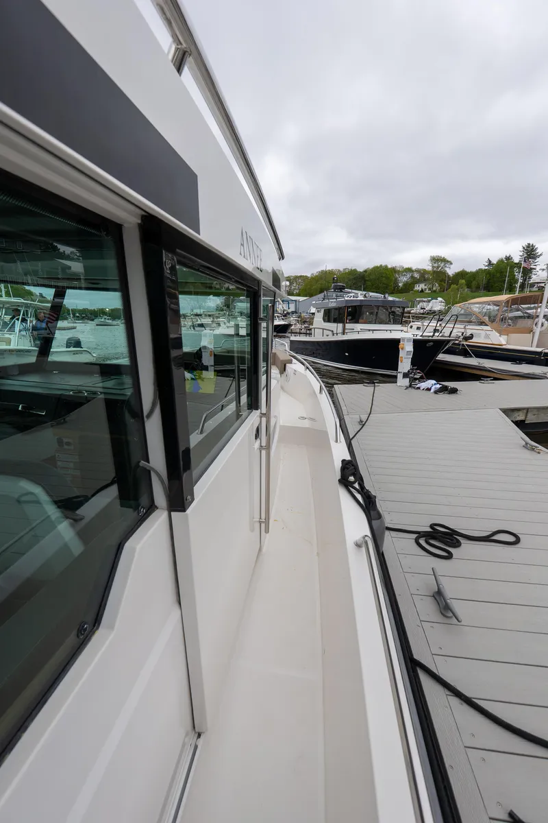 Slide: The Image of 2019 Axopar 37 Cabin boat docked at a marina, side view. - 13