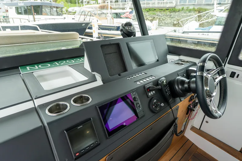 Slide: The Image of 2019 Axopar 37 Cabin helm with modern navigation equipment and steering wheel. - 18