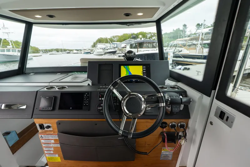 Slide: The Image of 2019 Axopar 37 Cabin helm with modern navigation equipment and steering wheel. - 20