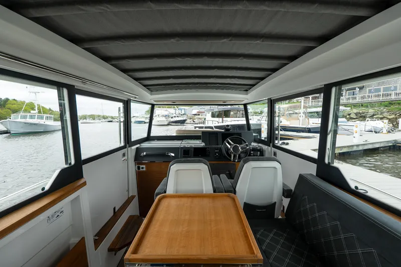 Slide: The Image of Interior of 2019 Axopar 37 Cabin boat with seating and table, docked at marina. - 21