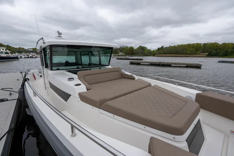 Slide: The Image of 2019 Axopar 37 Cabin boat with cushioned deck, docked on a cloudy day. - 4