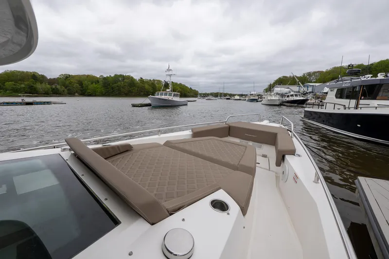 Slide: The Image of 2019 Axopar 37 Cabin boat with cushioned deck, docked in a scenic marina. - 5