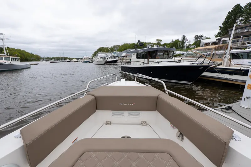 Slide: The Image of 2019 Axopar 37 Cabin boat docked in a marina, surrounded by other vessels. - 6