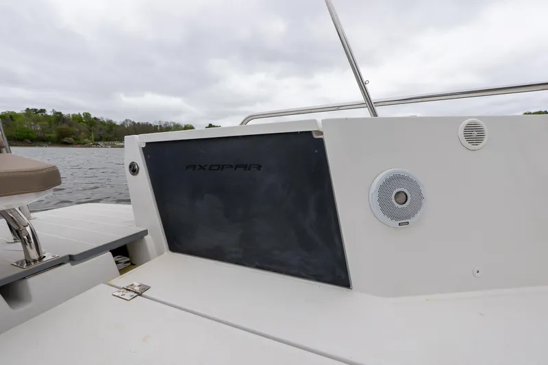 Slide: The Image of 2019 Axopar 37 Cabin boat deck with speaker and railing, overcast sky. - 8