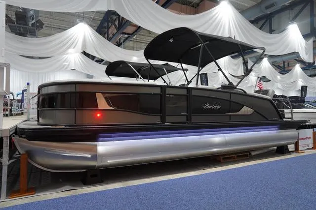 Slide: The Image of 2025 Barletta L23M pontoon boat displayed indoors with elegant drapery backdrop. - 1