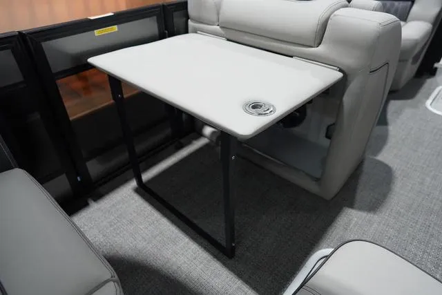 Slide: The Image of 2025 Barletta Boats L23M interior with foldable table and cup holder. - 16
