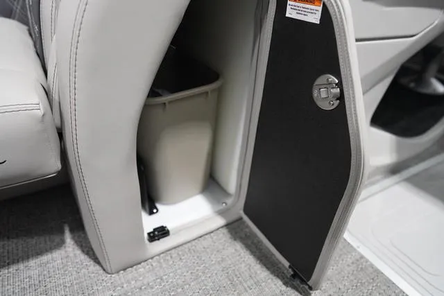 Slide: The Image of Open storage compartment in 2025 Barletta Boats L23M, featuring a built-in trash bin. - 4