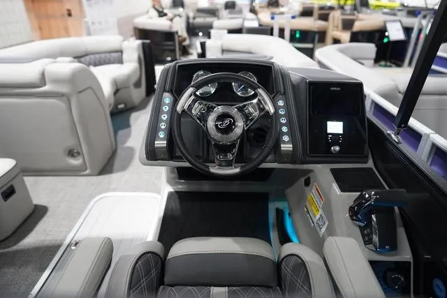 Slide: The Image of Interior view of 2025 Barletta Boats L23M, featuring modern steering and control panel. - 9