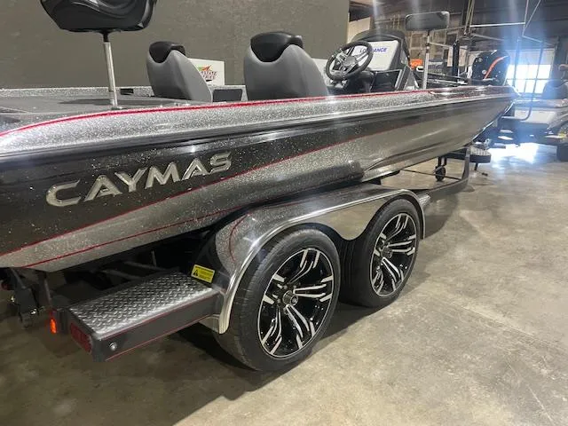 Slide: The Image of 2023 Caymas CX21Pro boat with sleek design and dual-axle trailer in showroom. - 3