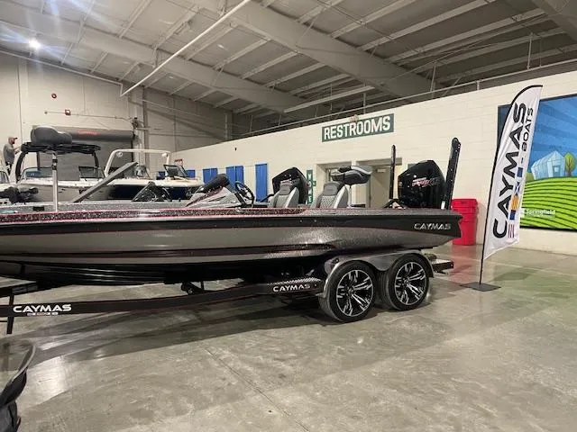 Slide: The Image of 2023 Caymas CX21Pro boat displayed indoors with trailer and promotional banner. - 9