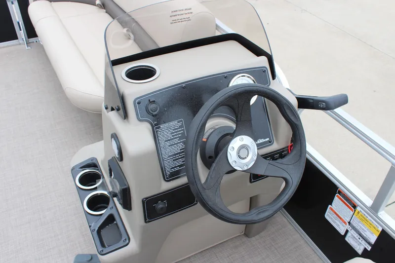 Slide: The Image of 2025 Sun Tracker Party Barge 16 DLX steering console with cup holders and controls. - 15