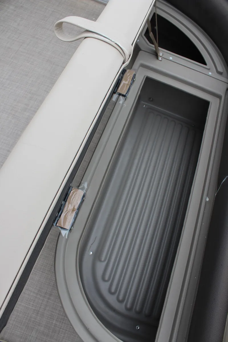 Slide: The Image of 2025 Sun Tracker Party Barge 16 DLX storage compartment with cushioned seating. - 20