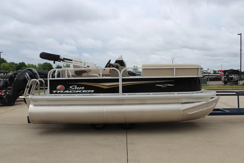 Slide: The Image of 2025 Sun Tracker Party Barge 16 DLX pontoon boat on display outdoors. - 4