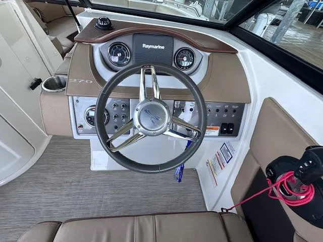 Slide: The Image of 2016 Sea Ray 270 Sundeck boat dashboard with steering wheel and control panel. - 16