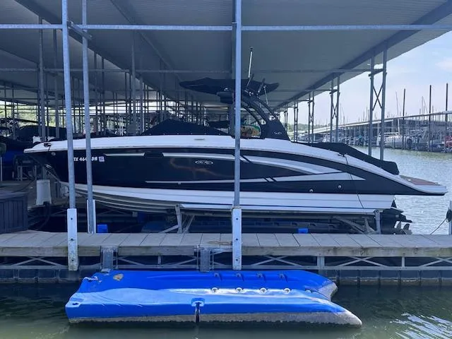 Slide: The Image of 2016 Sea Ray 270 Sundeck boat docked under covered marina. - 2